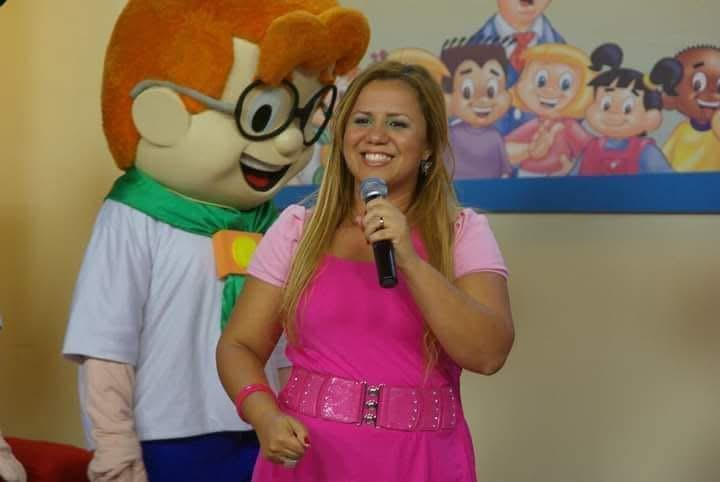 Aline na sala de seu apartamento com os primeiros bonecos.